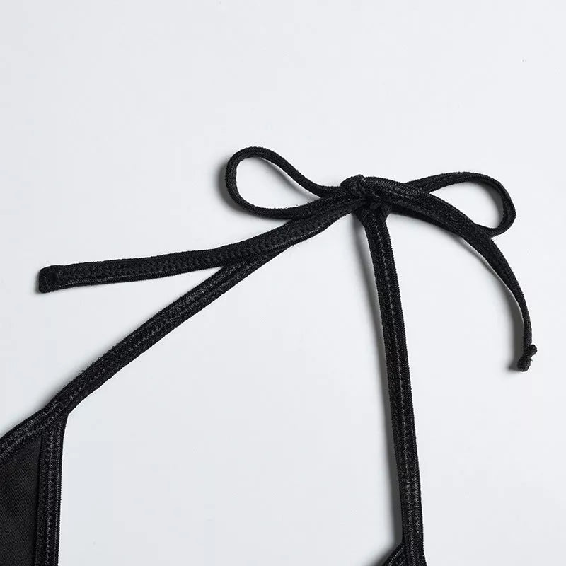 Solid black sling bikini set for women, includes bra, jacket, skirt, and shorts