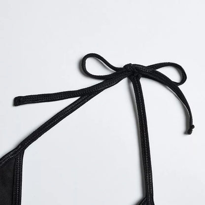 Solid black sling bikini set for women, includes bra, jacket, skirt, and shorts