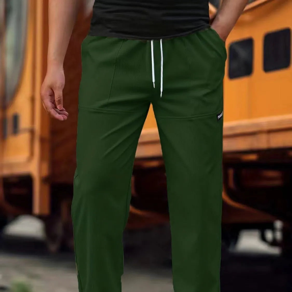 Men's polyester trousers for spring and autumn in light grey, shown in a casual setting