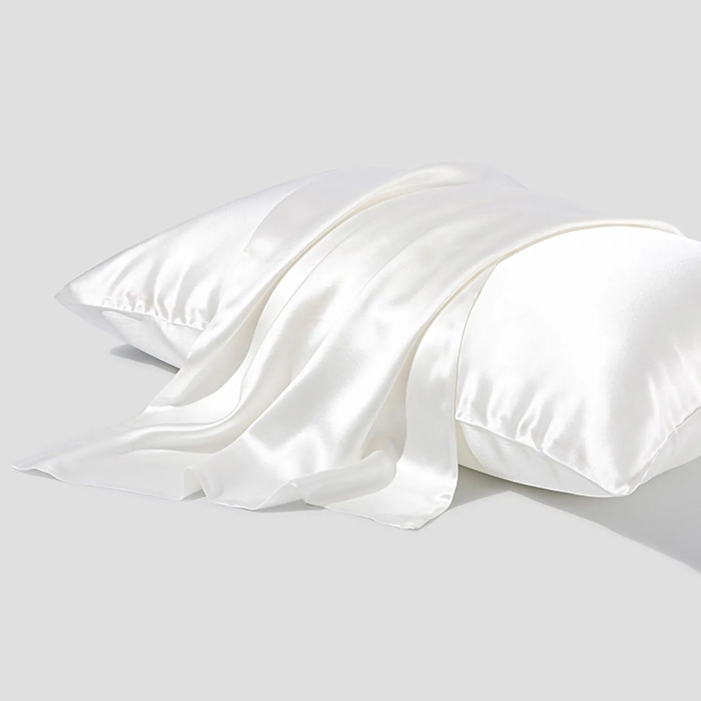 Dark grey silk pillowcase with envelope closure on a bed.