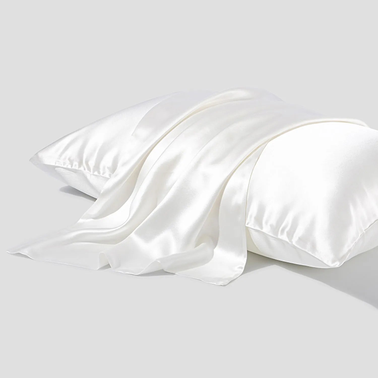 Dark grey silk pillowcase with envelope closure on a bed.