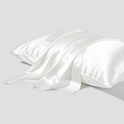 Dark grey silk pillowcase with envelope closure on a bed.