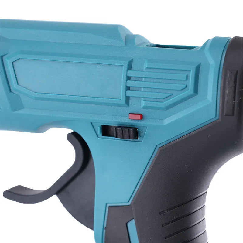 Cordless hot melt glue gun with bare metal body, two lithium batteries, charger, and pack of 11mm glue sticks.