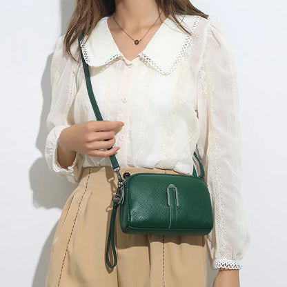 Women's genuine leather square shoulder bag in black, shown from front, displaying structured horizontal shape.