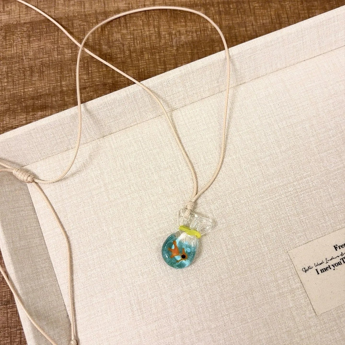 Women's necklace with coloured glaze pendant on a cotton-linen chain, showcasing world-style design