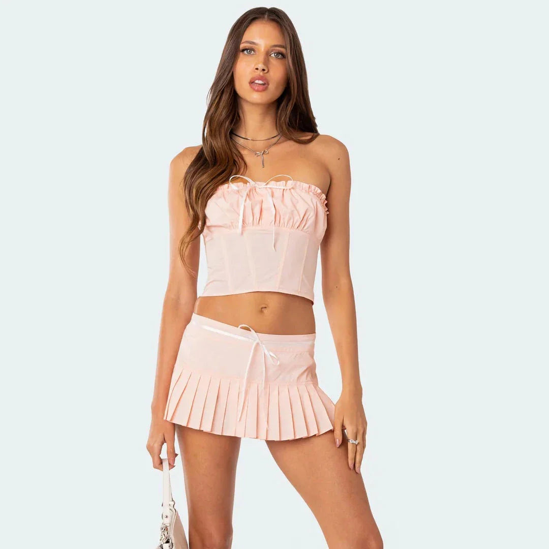 Chic strapless and pleated two-piece skirt set with a sleek, backless tube top and flirtatious, pleated mini skirt