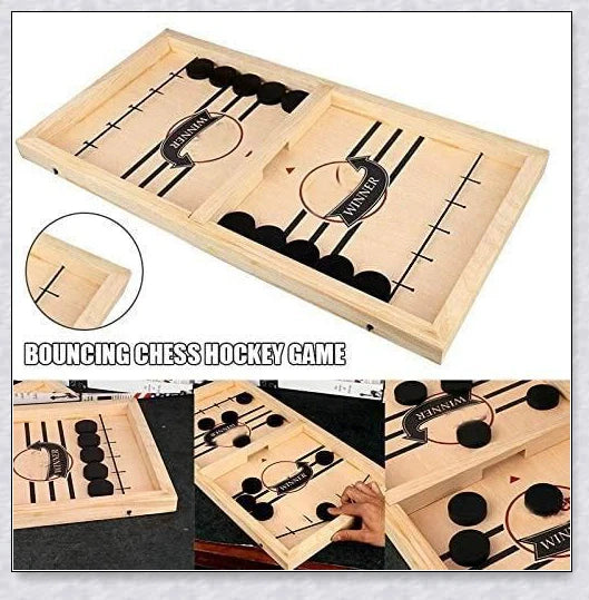 Two players competing in a wooden hockey game with pucks flying across the table