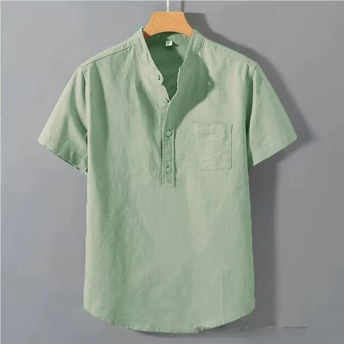 Man wearing a beige loose-fit linen blend casual shirt with a stand collar and short sleeves.