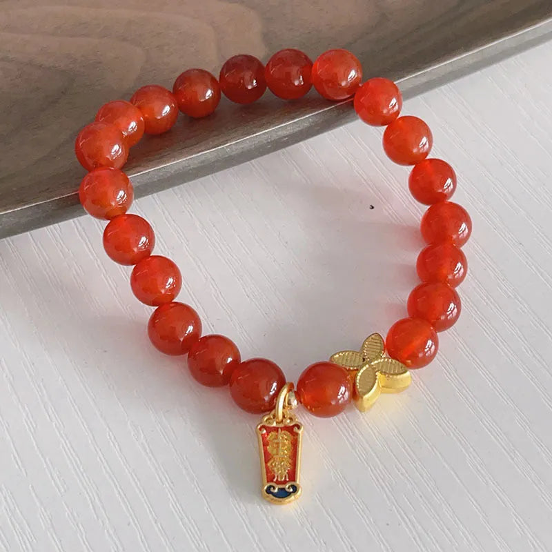 Close-up of a red agate bracelet featuring a detailed dragon design in a Chinese style.
