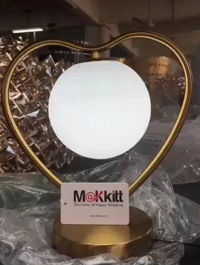 Heart-shaped polyresin table lamp with warm white LED light on a wooden surface