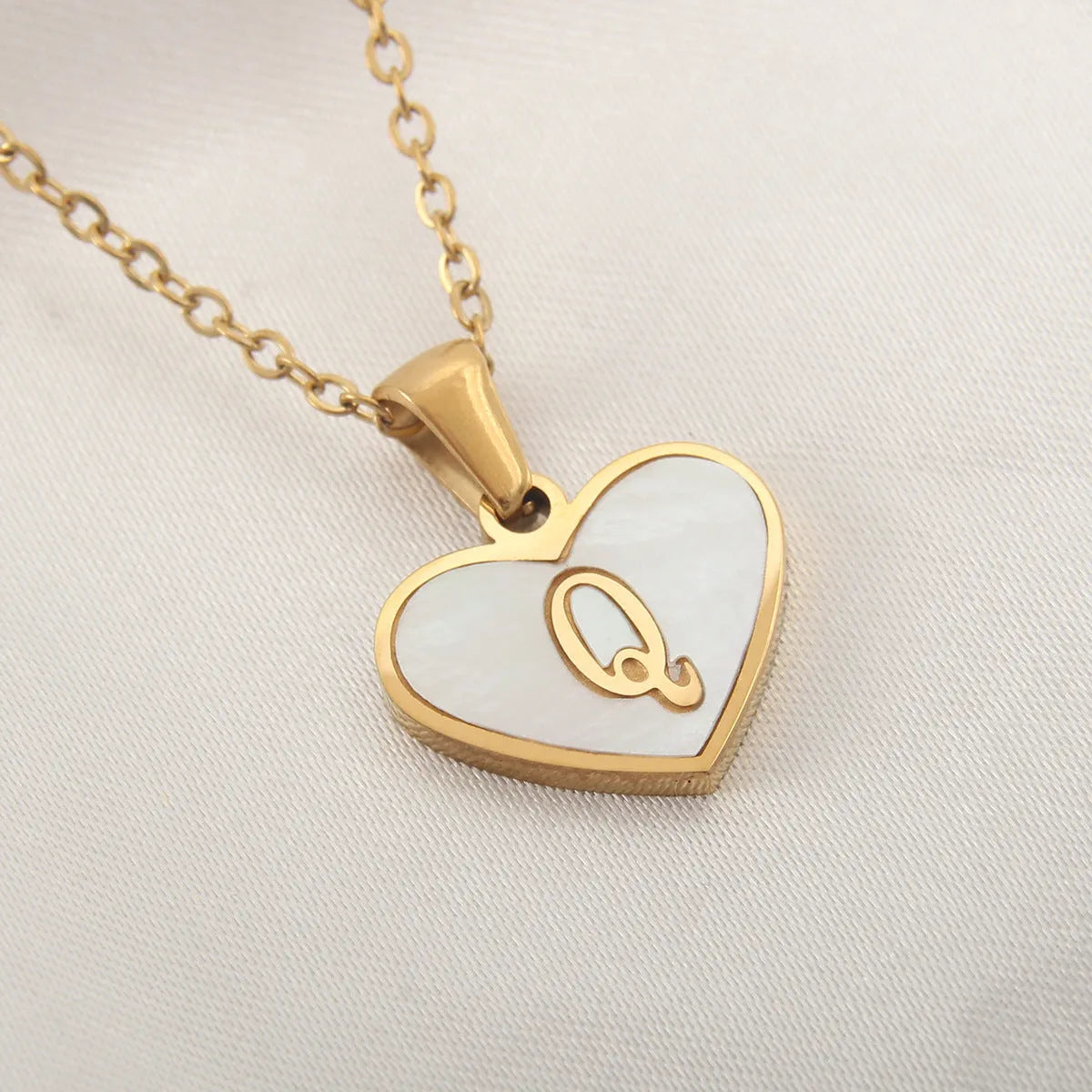 Gold-plated clavicle necklace with a white shell heart pendant, personalised with a letter from A to Z.