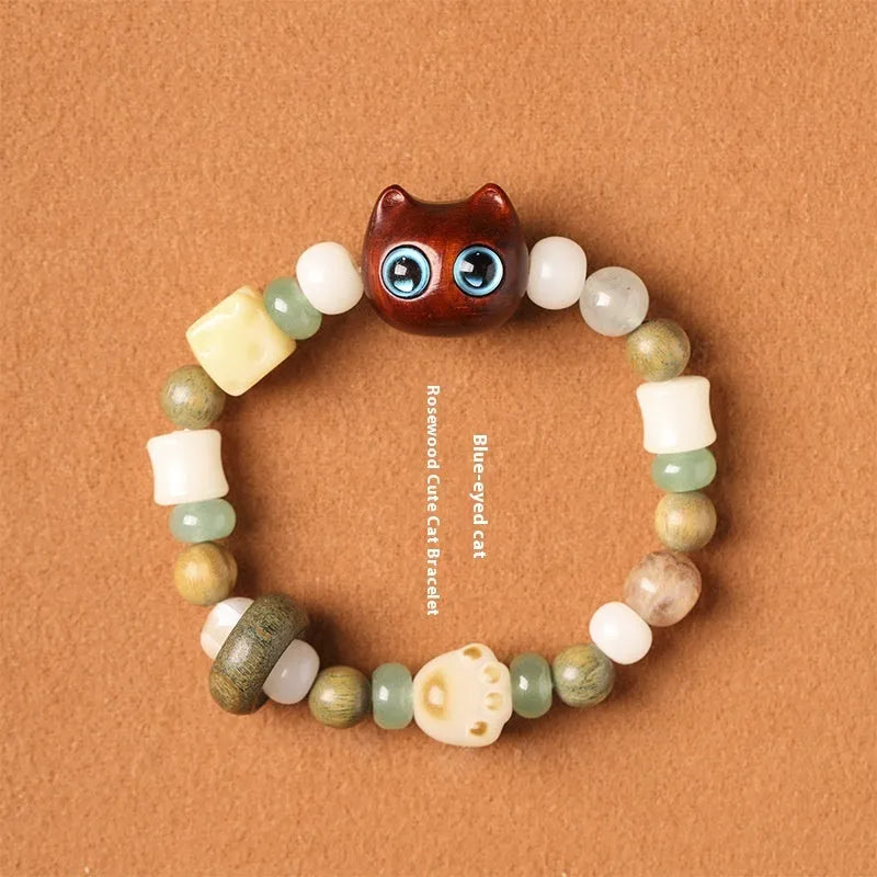 Hand-woven multi-treasure bracelet with jade, bodhi and ebony wood beads and a cartoon cat's paw charm.
