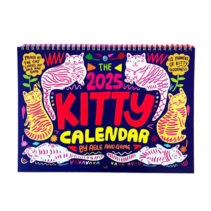 Cat-themed paper wall calendar for 2024 or 2025 year, showing monthly grid with feline artwork.