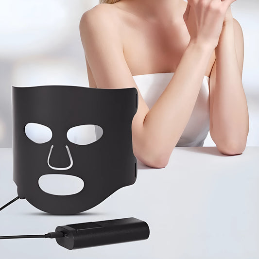 Black and white LED phototherapy face mask with controller showing seven colour light therapy options
