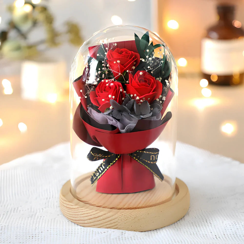 Soap flower bouquet in glass display cover with red roses visible through clear 11.2cm dome