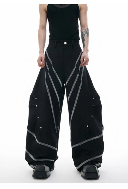 Men's trousers with three-dimensional cutting and metal striped rivet pleats in black or white, showing tailored fit and detail