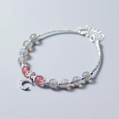 Natural moonlight-coloured moonstone bracelet with silver crescent moon charm on adjustable chain.