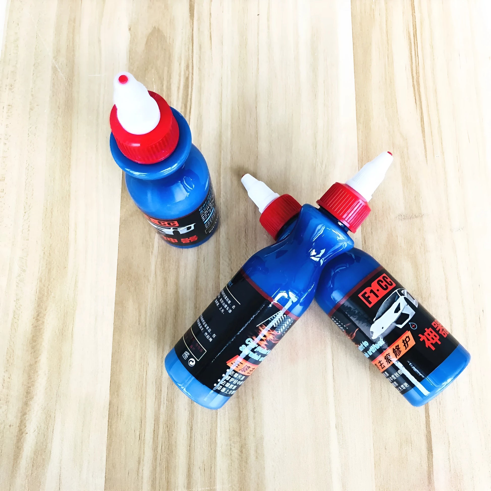 Blue car scratch repair agent container with microfiber cloth for minor automotive surface imperfections