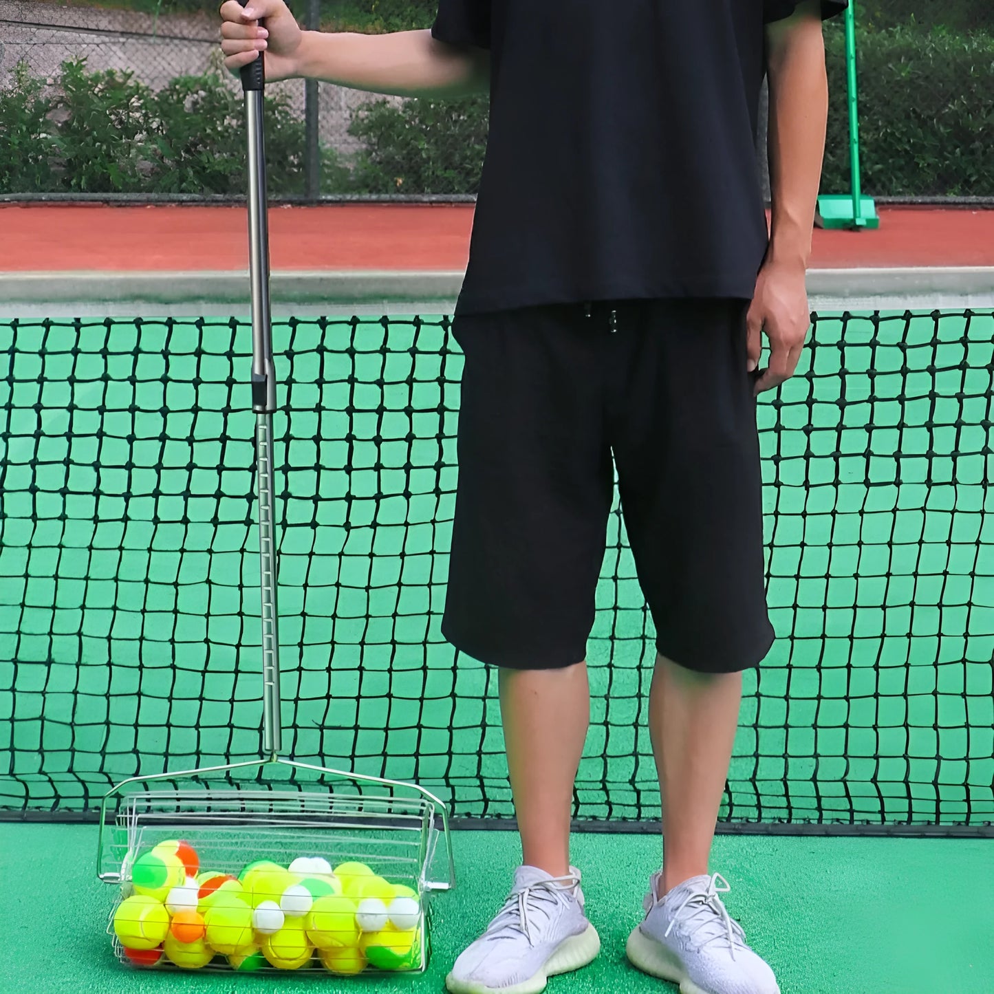 Stainless steel roller tennis ball picker on a court surface