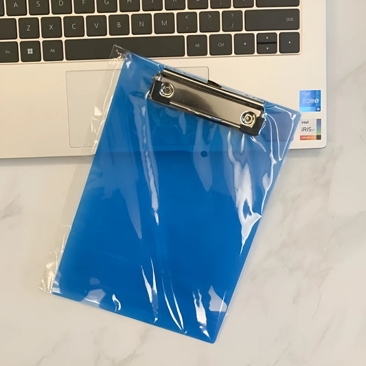 Transparent A4 writing board pad with metal flat clip in blue, alongside A5 size in red on a desk.