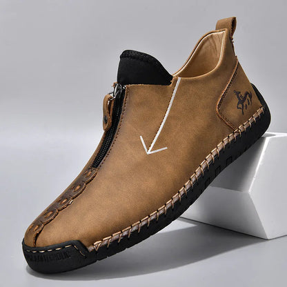 Men's black leather boots with front zipper, hand-stitched detailing, and rubber sole on a neutral background