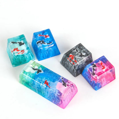 Close-up of a custom resin keycap featuring a detailed blue and orange koi fish scene, designed for Cherry MX mechanical keyboards.