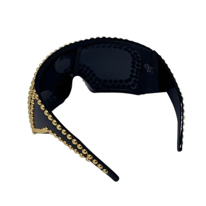 Square punk sunglasses with large rim and rivet detailing in gold colour