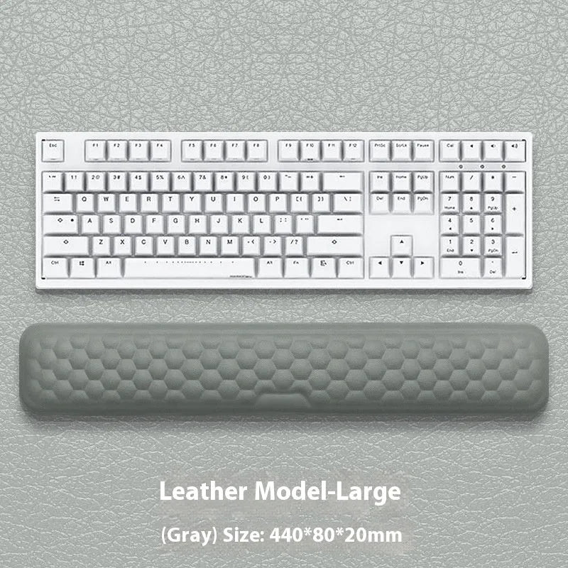 Black and grey memory foam mouse wrist rests with cloth and leather-style covers on a desk.