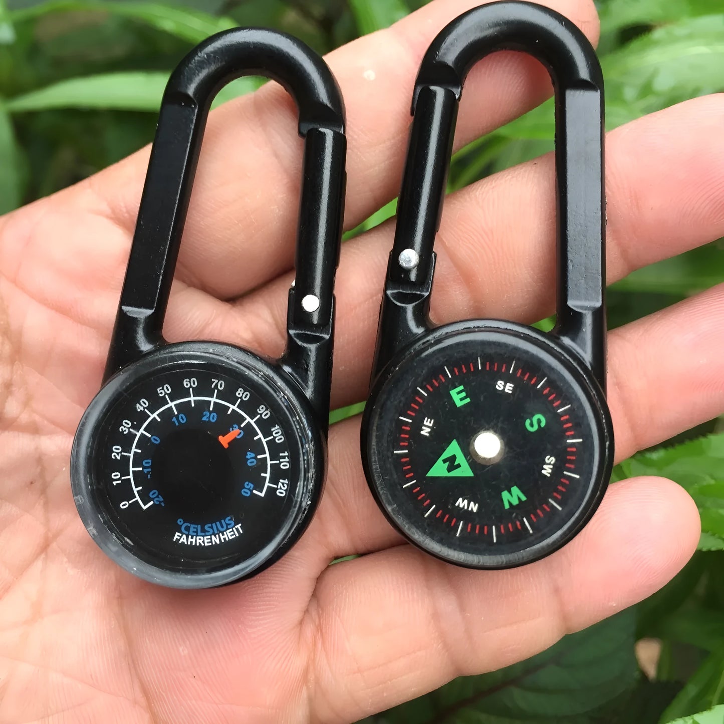 Black outdoor carabiner with a built-in circular compass and thermometer display on its side.