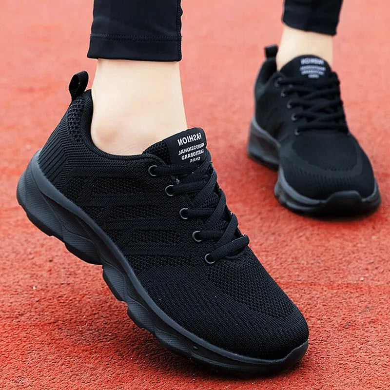 Women's white mesh fabric lace-up leisure shoes with a low heel on a plain background.