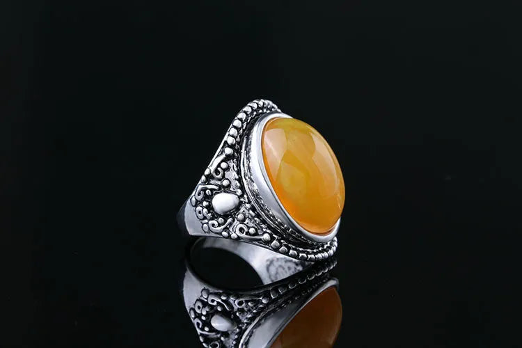 Geometric antique silver amber alloy ring with fluorescent beeswax plating on a model's finger.