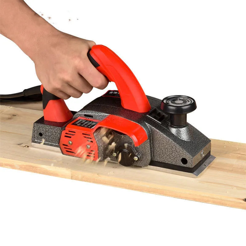Red desktop electric wood planer with aluminium shell showing 82mm planing width