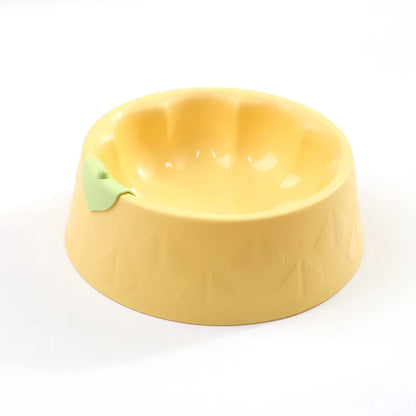 Green plastic double pet bowl with two compartments for food and water on a flat surface.