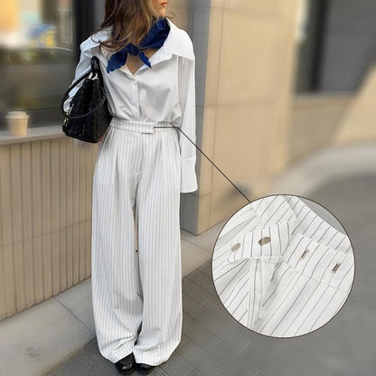 White striped wide-leg casual trousers with a front zipper on a hanger.