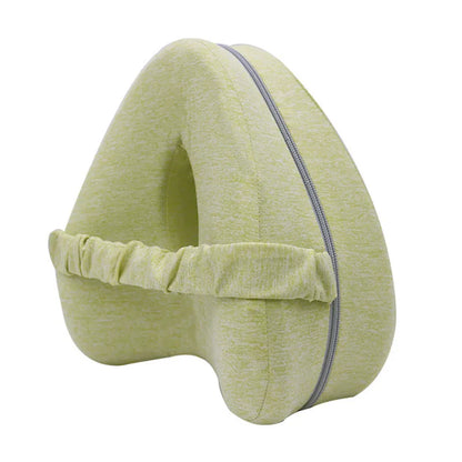 Dark blue jacquard heart-shaped memory foam leg pillow for adults on a bed.