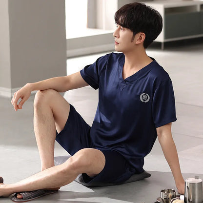 Man wearing a loose fit light blue ice silk short-sleeve pajama shirt and matching shorts.