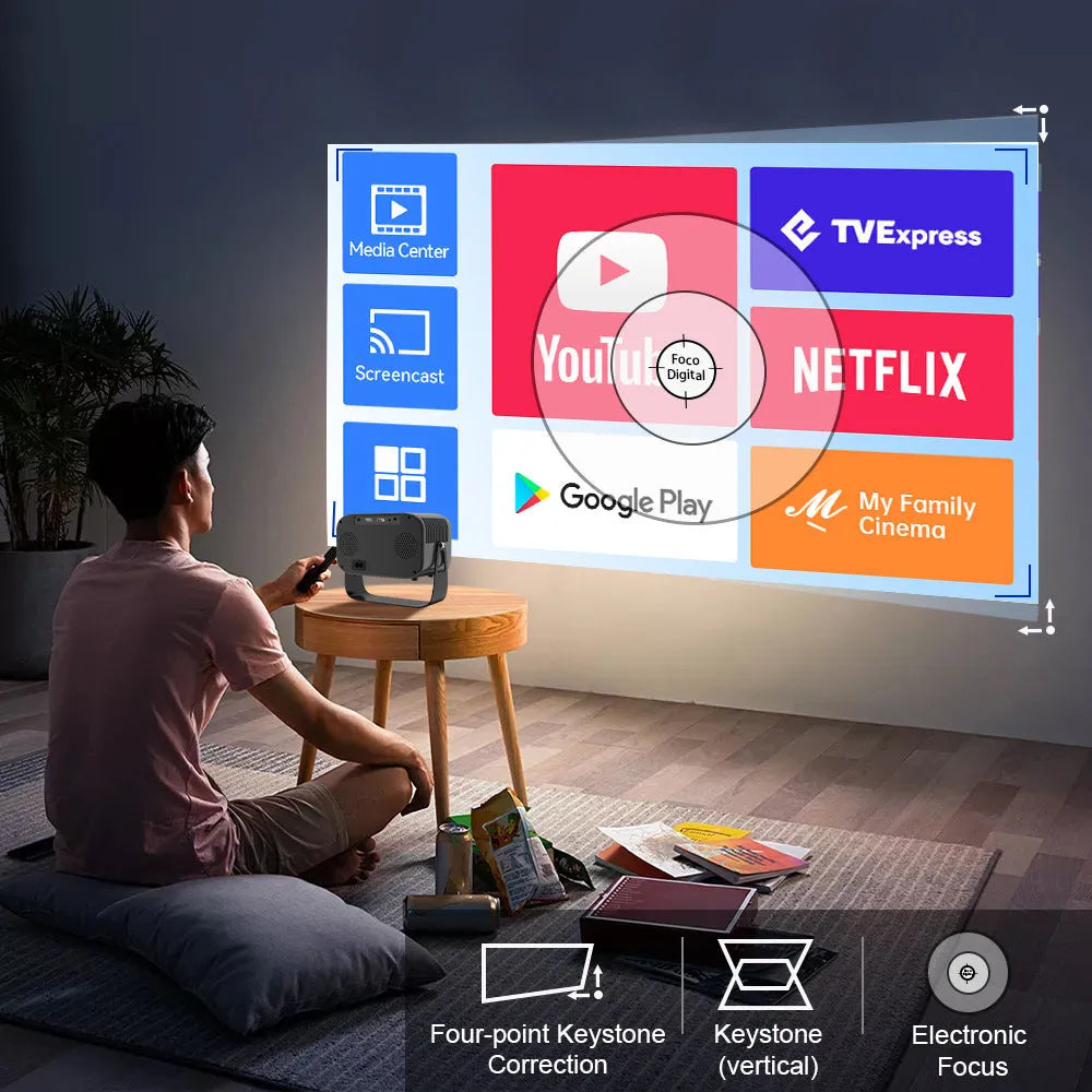 Black HD smart portable projector with remote control and cables on a table