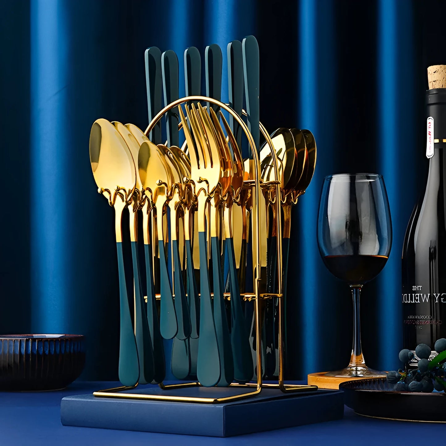 24-piece stainless steel cutlery set with knives, forks, spoons, and teaspoons on a storage rack in a gold finish.