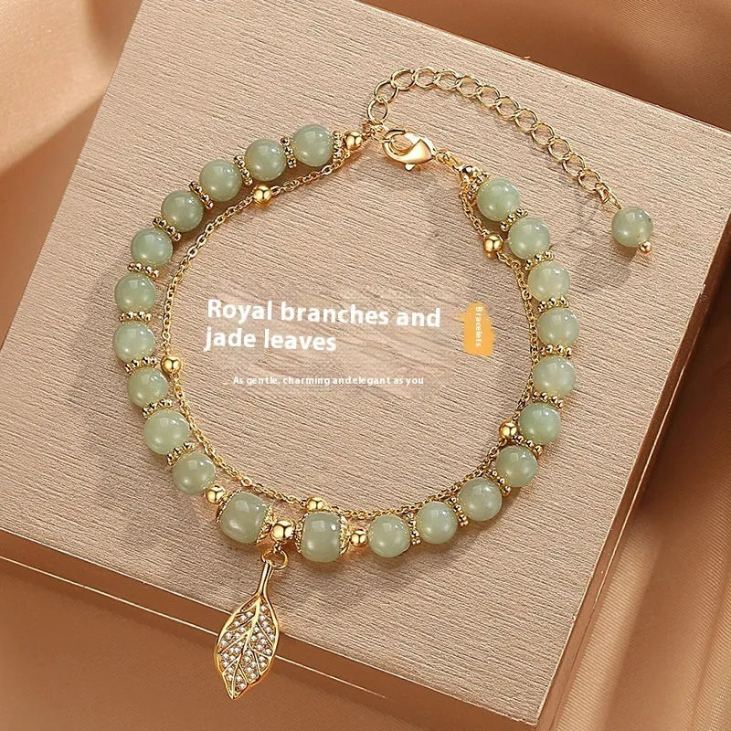 Chinese style glass bead bracelet with bamboo joint design on wrist.