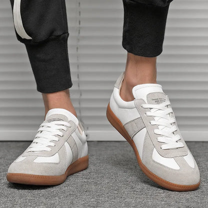 White Japanese-style retro low-top sneakers with round toe and flat rubber sole on a plain background.