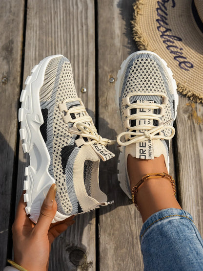 Women's Flyknit mesh lace-up sneakers in a grey colourway on a white background