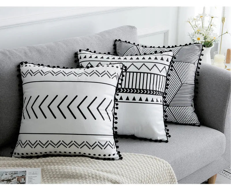 Bohemian style decorative pillowcase in light grey colour on a sofa.