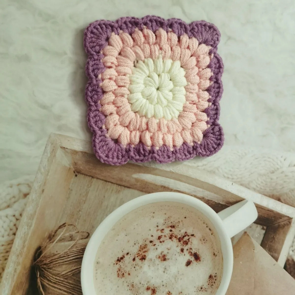 Crocheted wool cup coaster with grandmother lattice pattern in selected colour