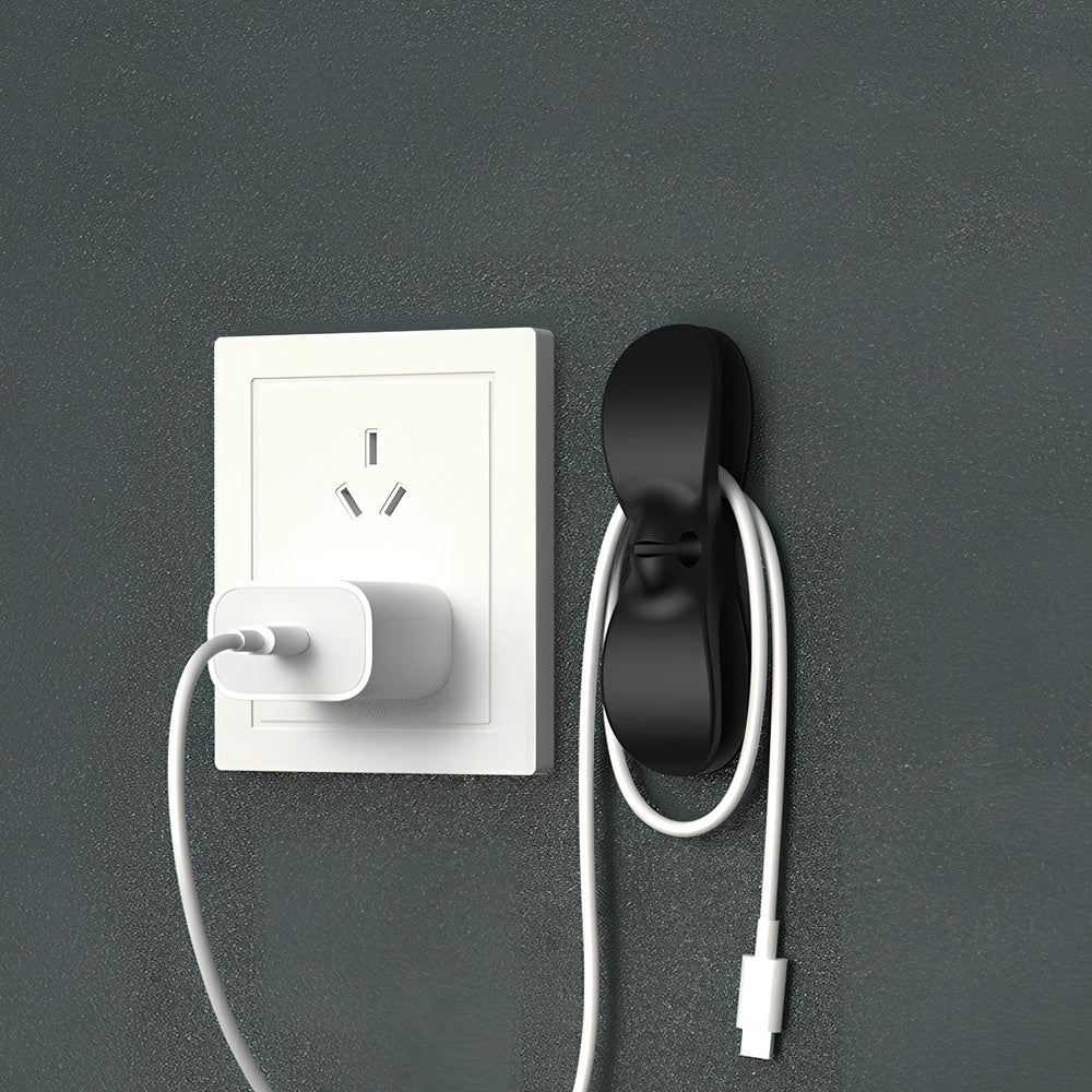 Black TPU cable organizer clips winding appliance cords on kitchen counter, 5cm size, non-marking adhesive for tidy management