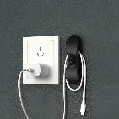 Black TPU cable organizer clips winding appliance cords on kitchen counter, 5cm size, non-marking adhesive for tidy management