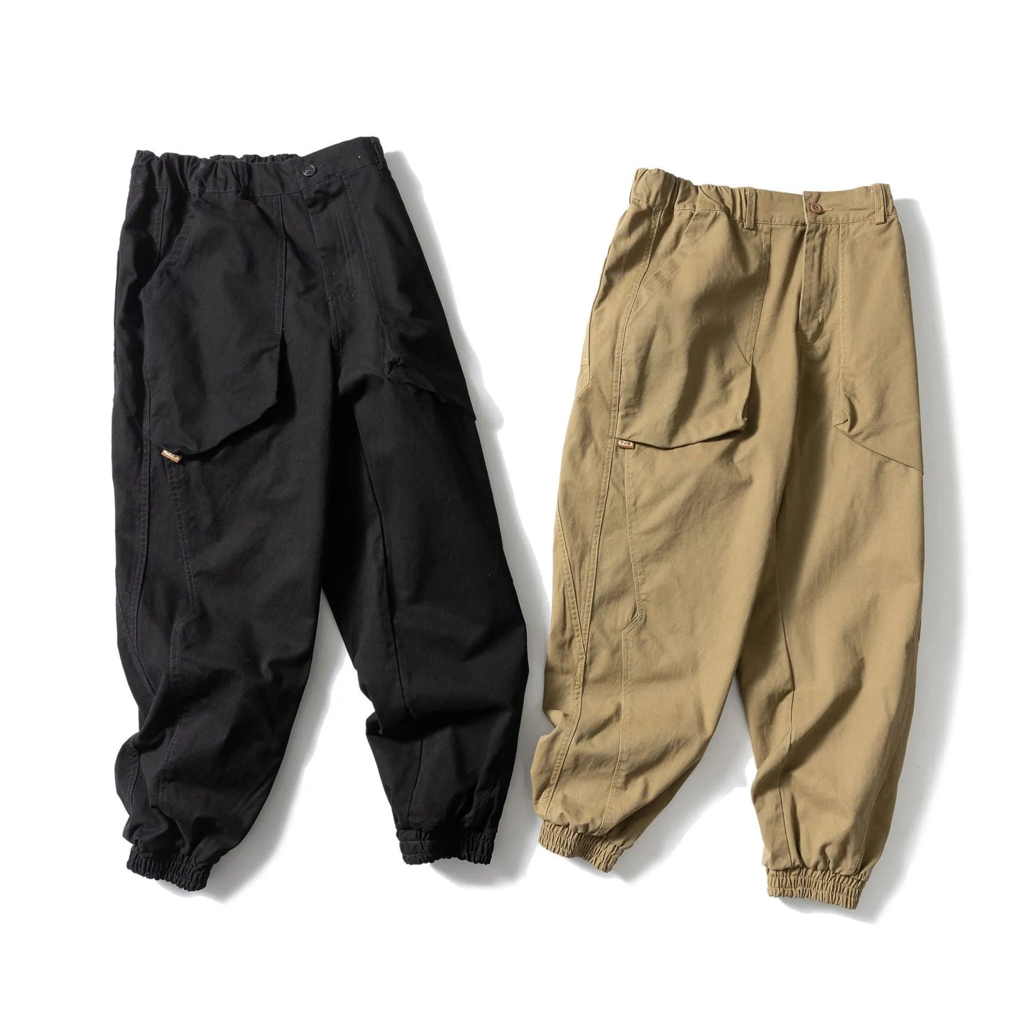 Black cotton casual pants with large pockets, tapered legs, and ankle ties on a hanger.