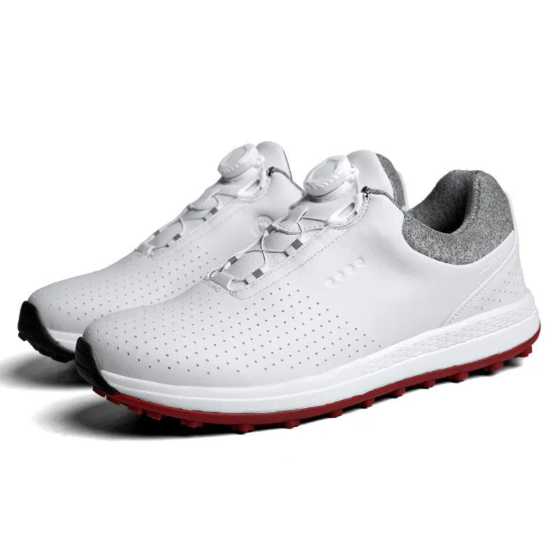 Men's white and black casual golf shoes with perforated upper and low-top design on a grass surface.