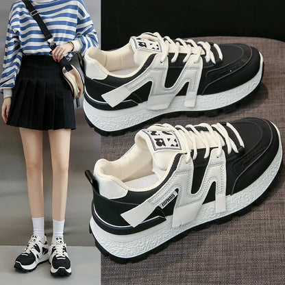 White low-top unisex sneaker with round toe and flat rubber sole on a plain background.