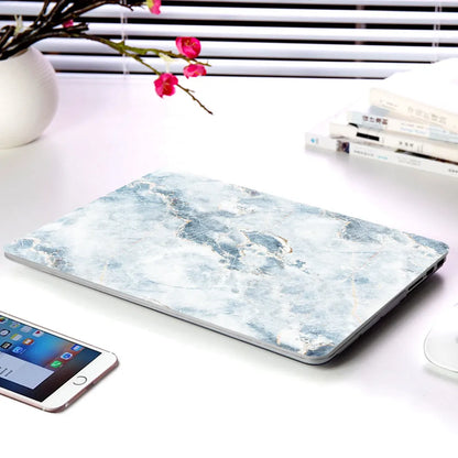 Plastic MacBook protective case in a marble pattern colour, shown next to a compatible Apple laptop.