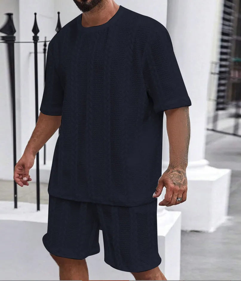 Knitted short-sleeve pullover and matching shorts set in light grey, laid flat.